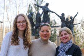 Vicky Marsch, Julia Dahmen und Gabi Helgert stehen lächelnd vor eine Statue von Don Bosco.